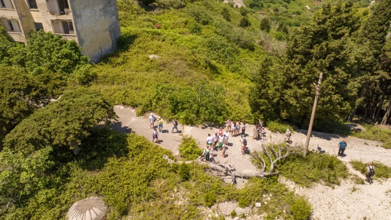 grupa turystów zwiedza opuszczone miasto na wyspie Sazan