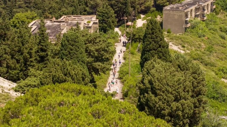 grupa turystów zwiedza opuszczone miasto na wyspie Sazan